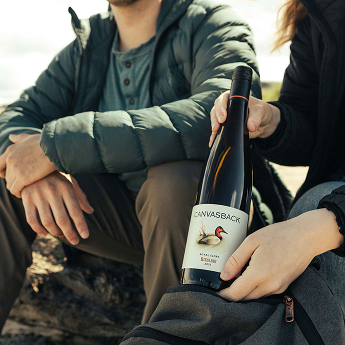 Couple at the beach with bottle of Canvasback wine