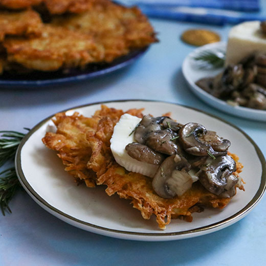 Latkes topped with herb roasted mushrooms with brie.