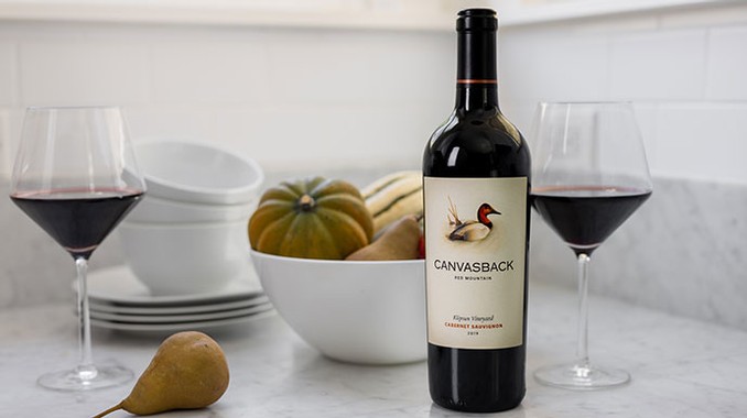 Canvasback wines on the counter next to bowl of gourds