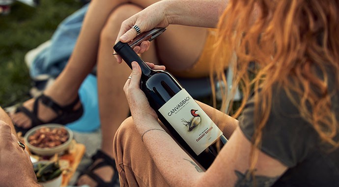 Person using foil cutter on Canvasback wine bottle