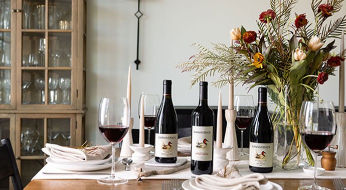 Canvasback wines on a dining table with a bouquet of flowers