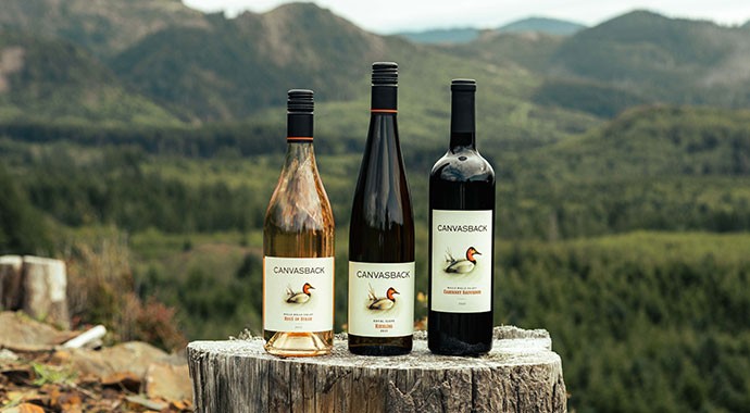 Canvasback wines outdoors on a tree stump