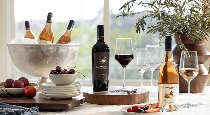 Canvasback wines on a dining table with a bouquet of flowers