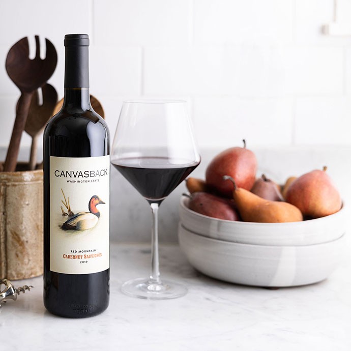 Canvasback wine on counter with a bowl of pears