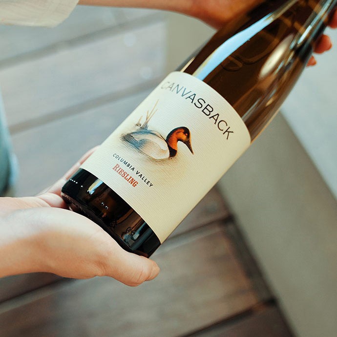 Canvasback Riesling bottle held in hands with label prominent