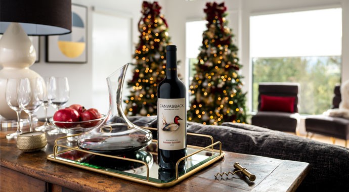 Canvasback wine on the table with Christmas trees in the background